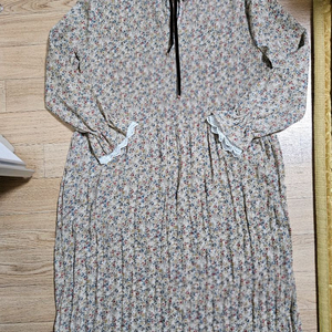 잔잔한 플라워 패턴이 매력적인 롱 원피스입니다. 66사이즈이며, 플리츠 디테일과 레이스 장식이 더해져 여성스러움을 이미지