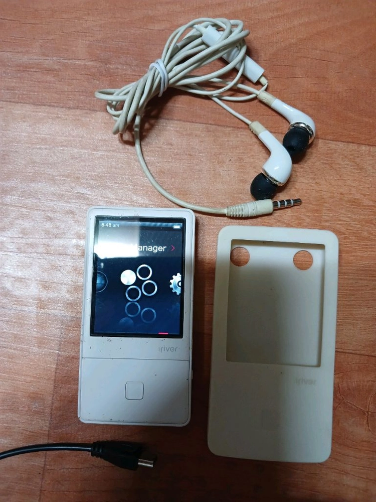 아이리버 E100 8G MP3 플레이어 화이트 색상입니다. 이어폰과 케이스,충전기,USB리드선 이미지